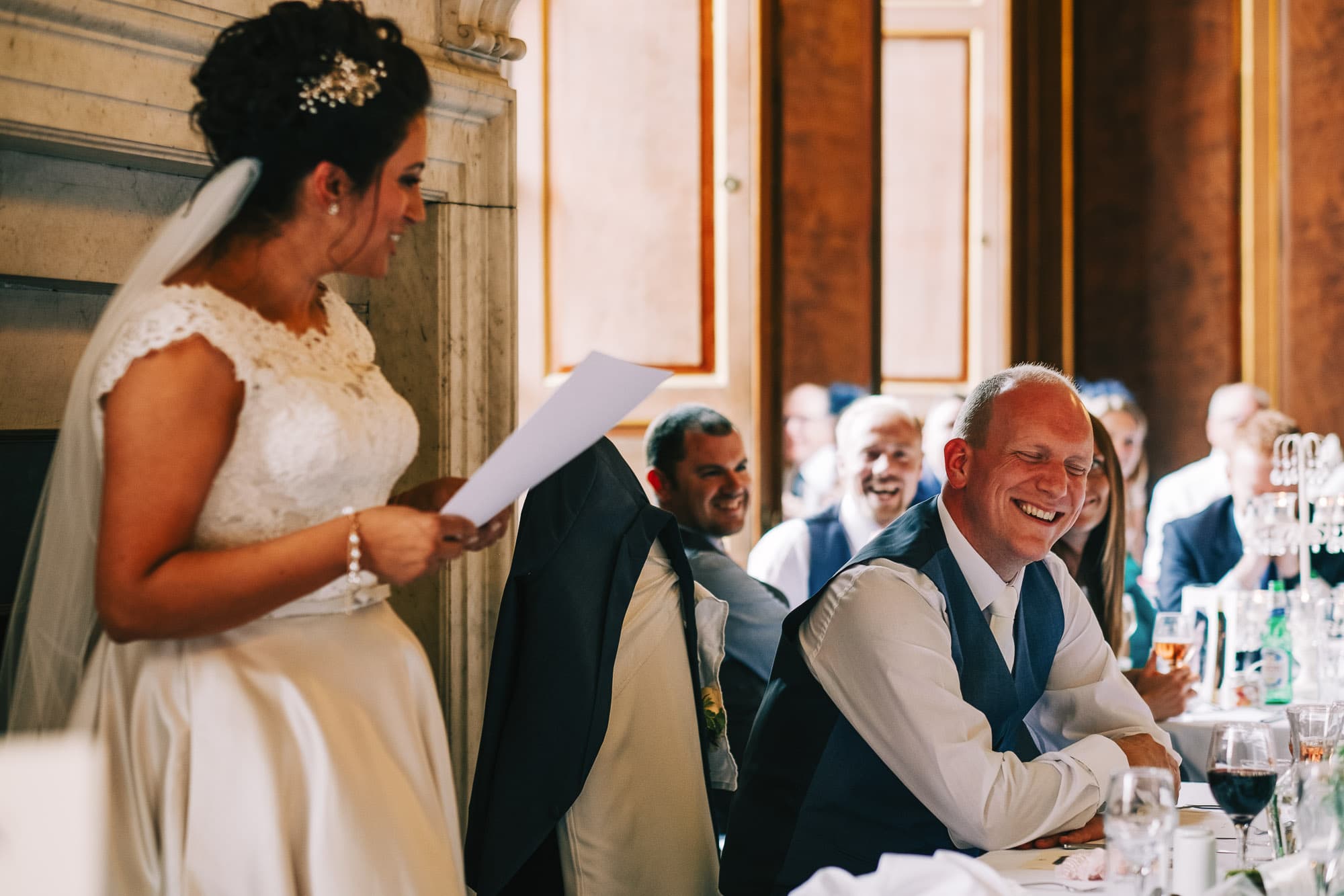 Groom laughing at brides speech