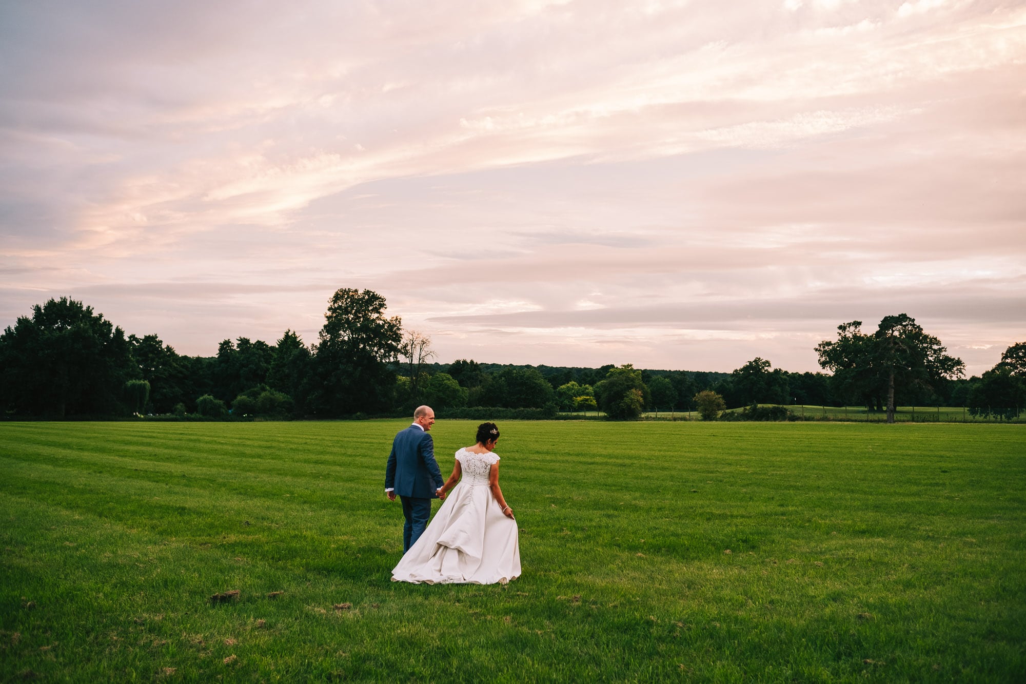 Bride and groom walking in Gosfield Hall grounds