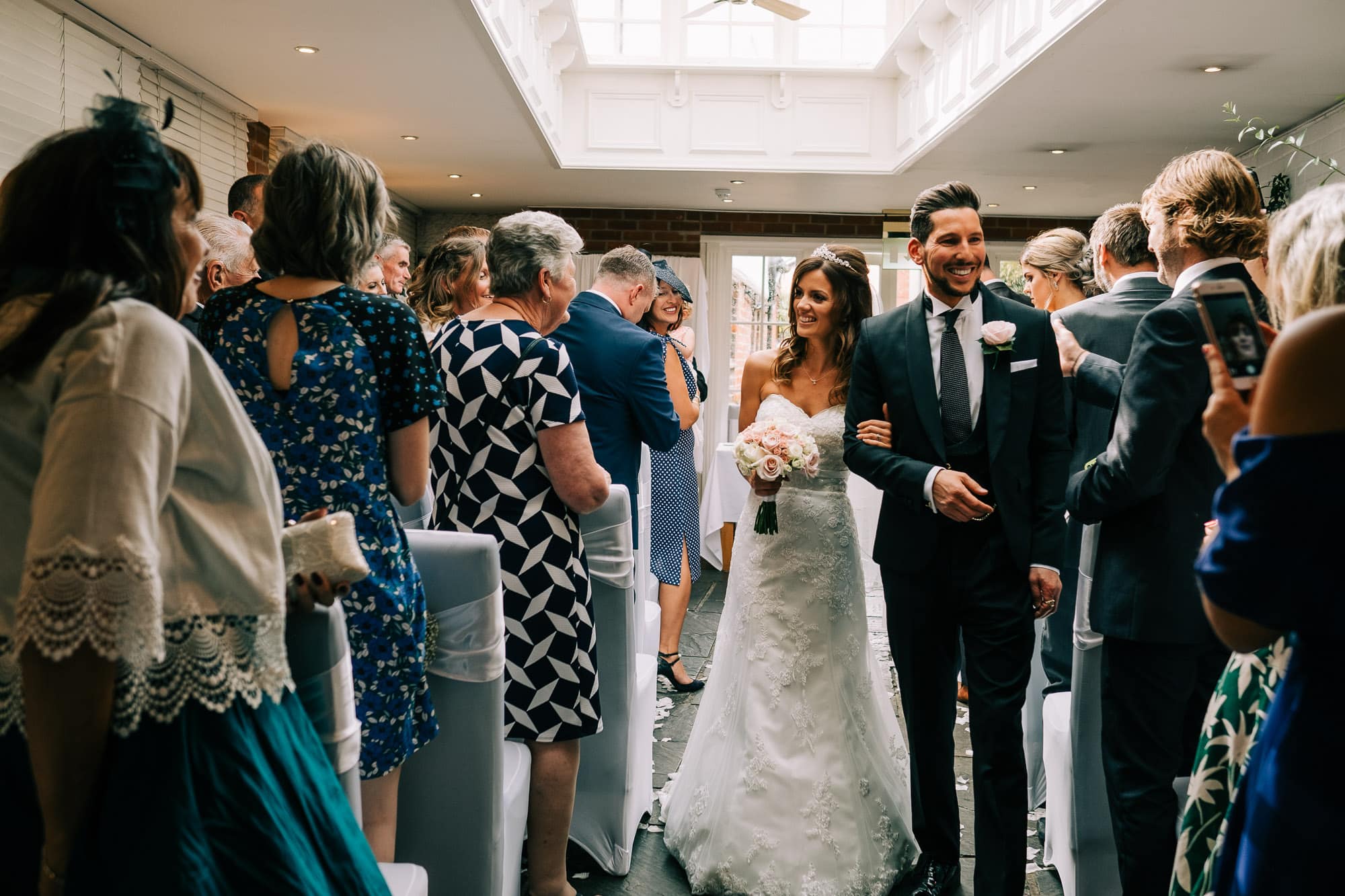 Bride and groom walk down the aisle at the George Hotel in Buckden