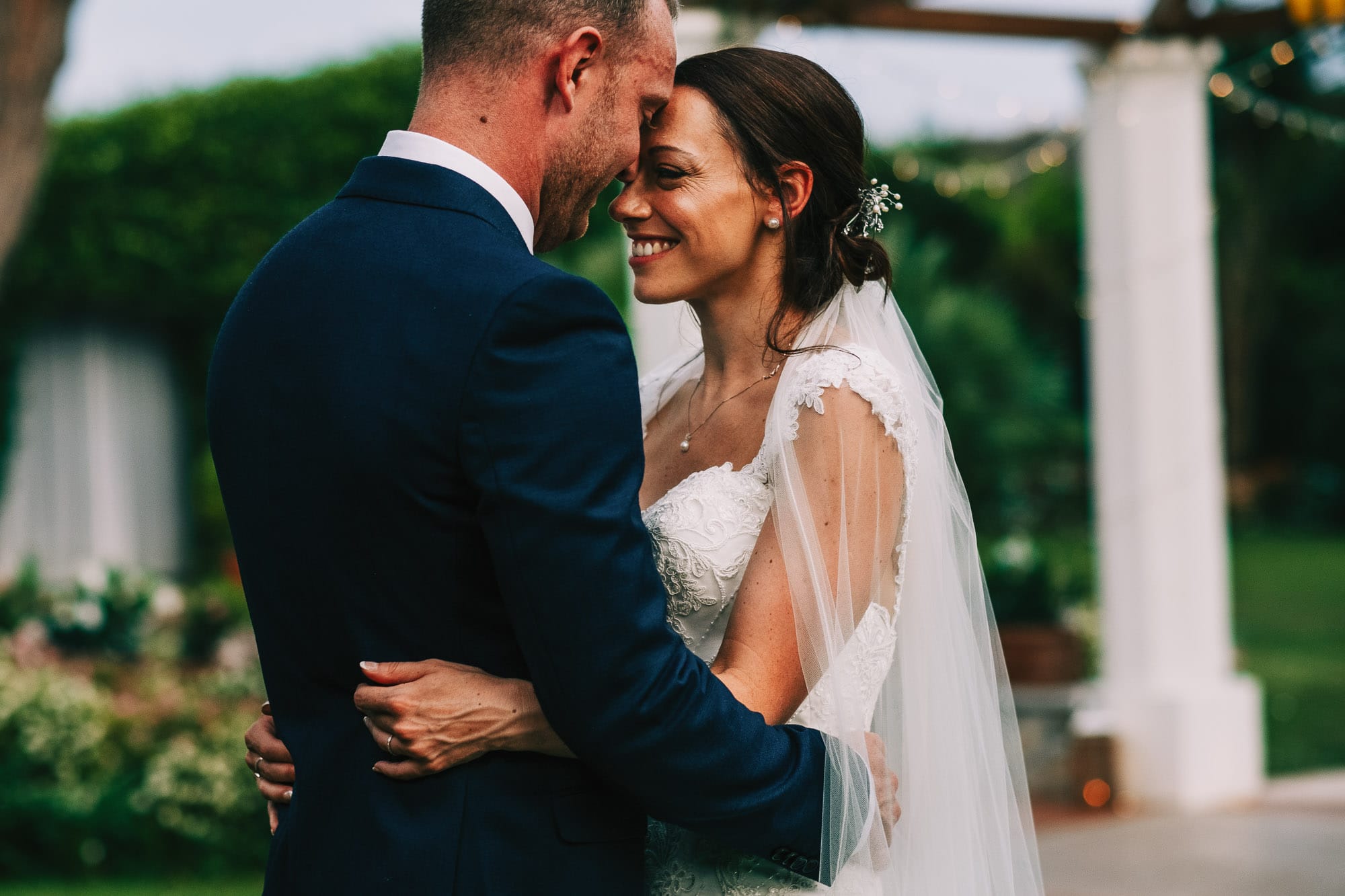 Groom kisses brides head in Villa Eva in Ravello