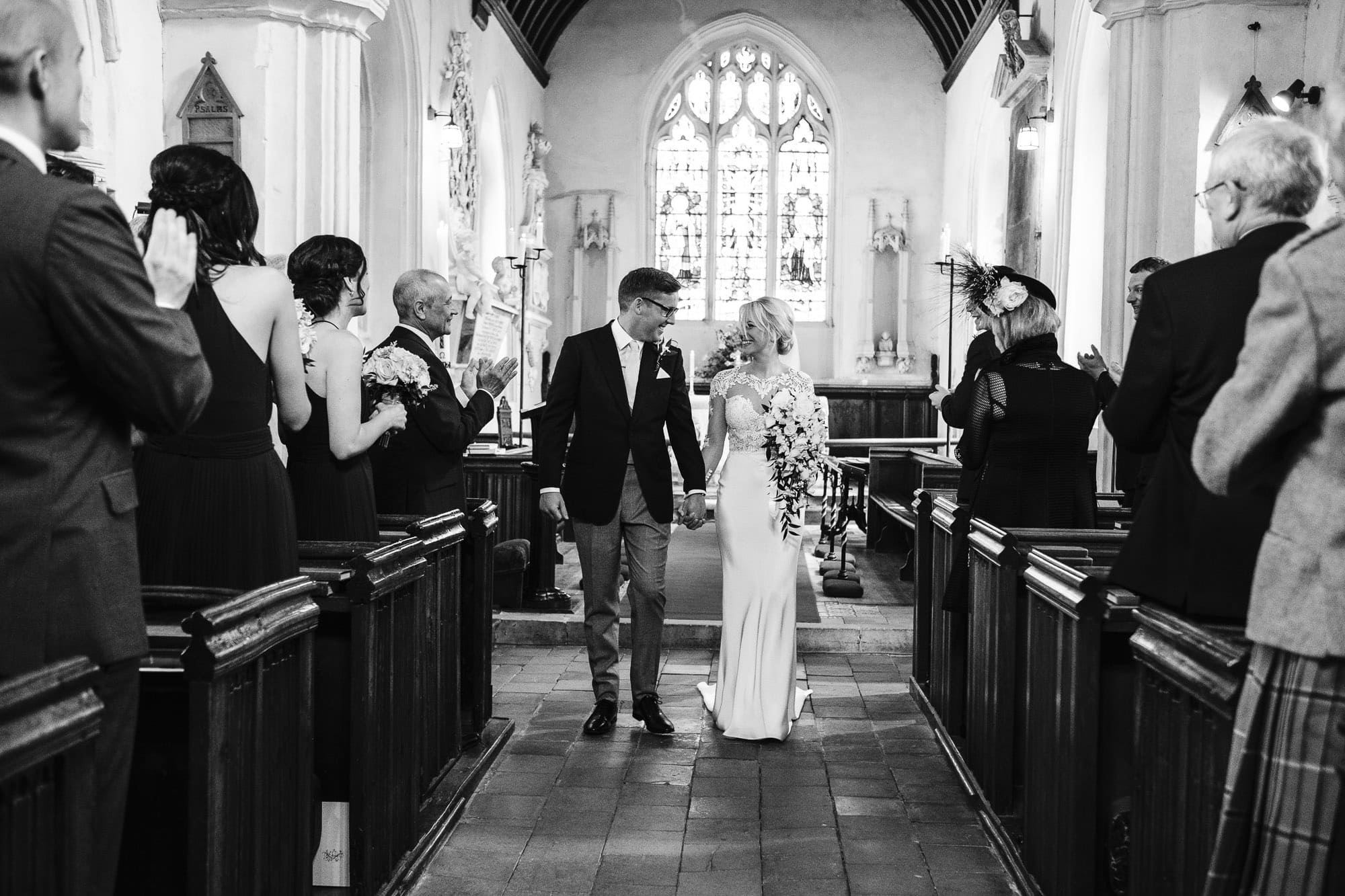 Bride and groom walking down the aisle of the church