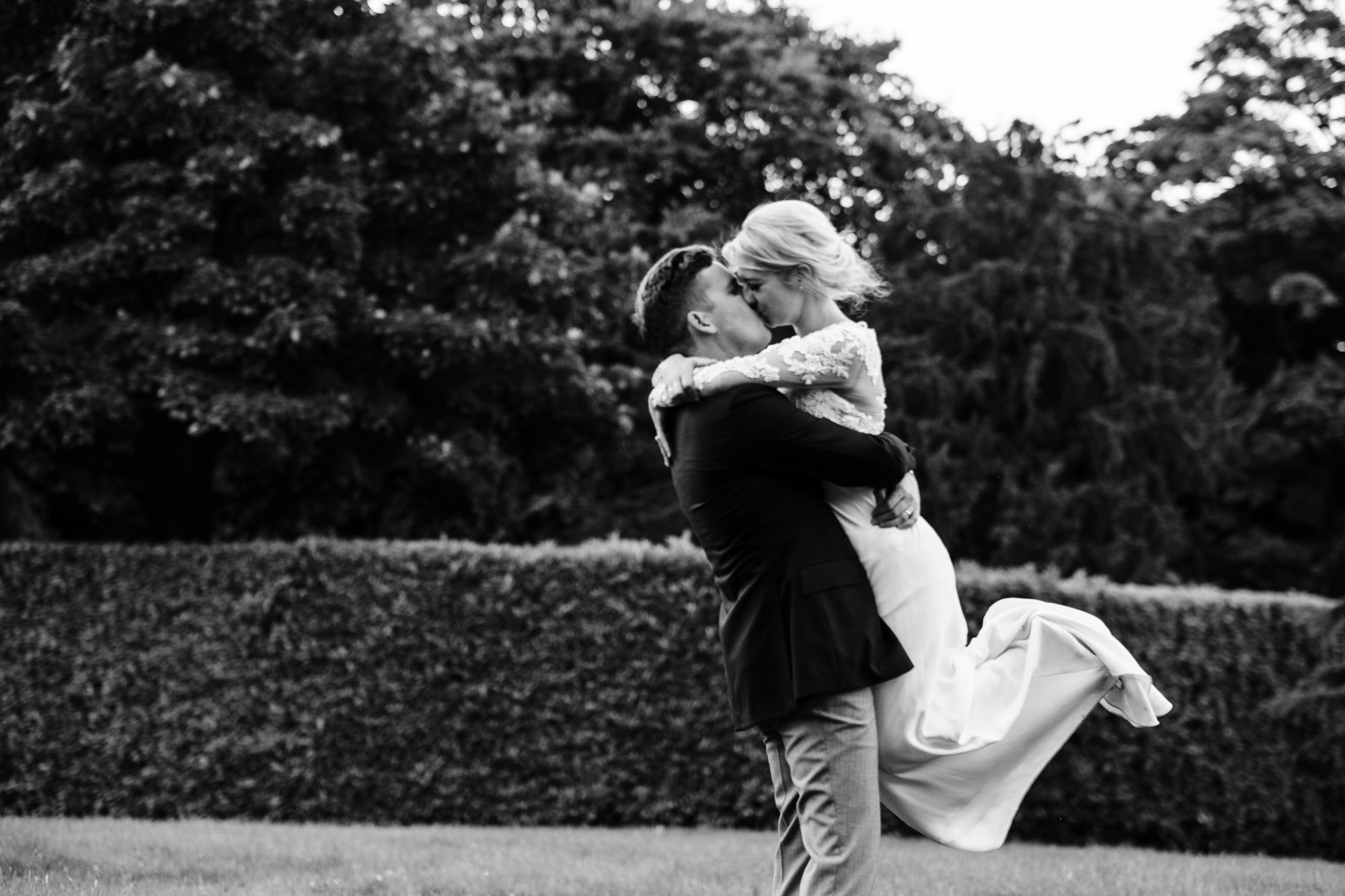 Groom lifts up the bride and kisses her