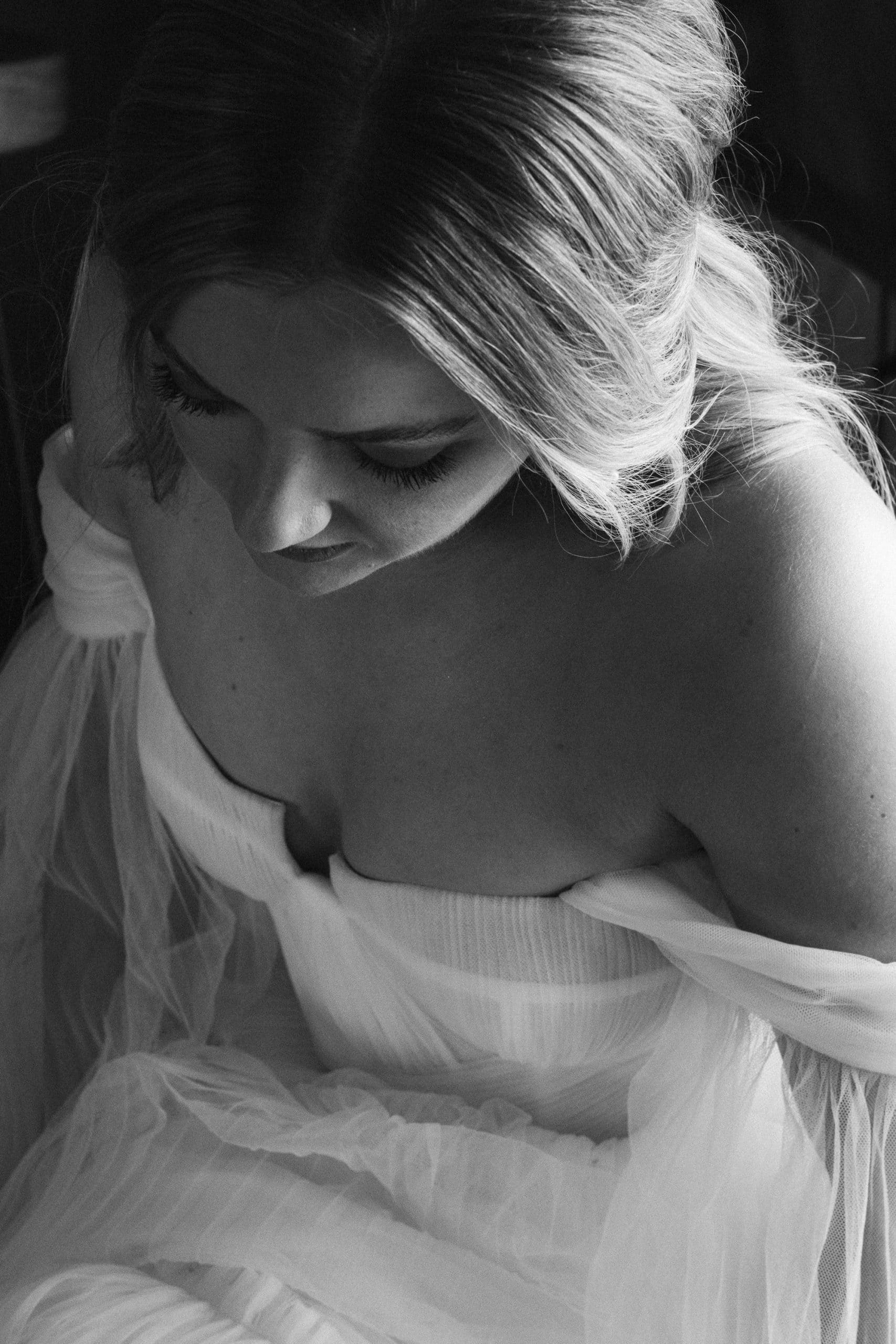 Bride sitting waiting to leave for the wedding ceremony with gorgeous light on her face