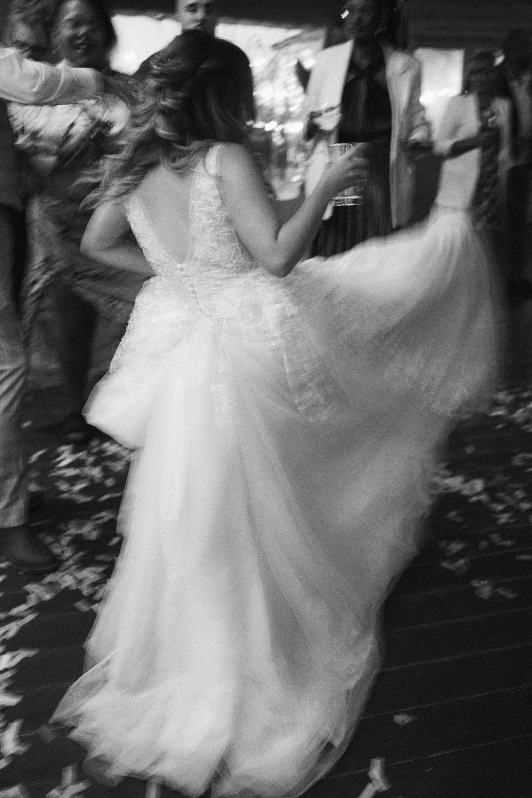 Bride shakes her dress on the dance floor