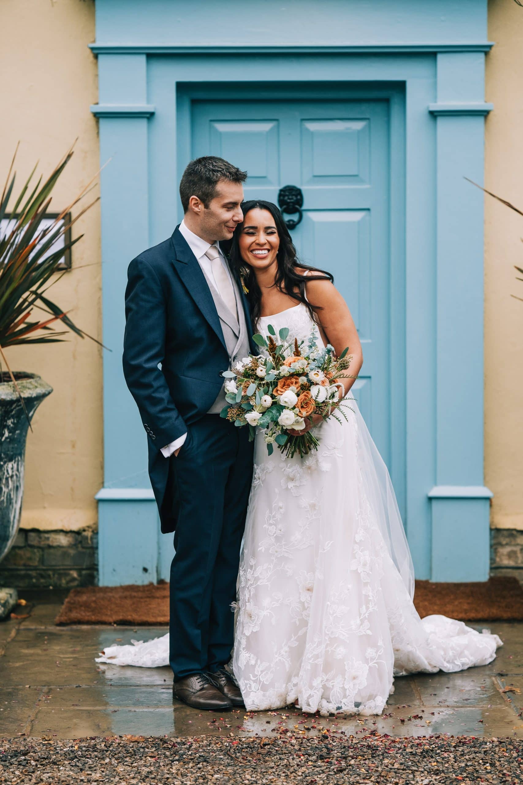 Bride and groom have a cuddle in front of the house at South Farm