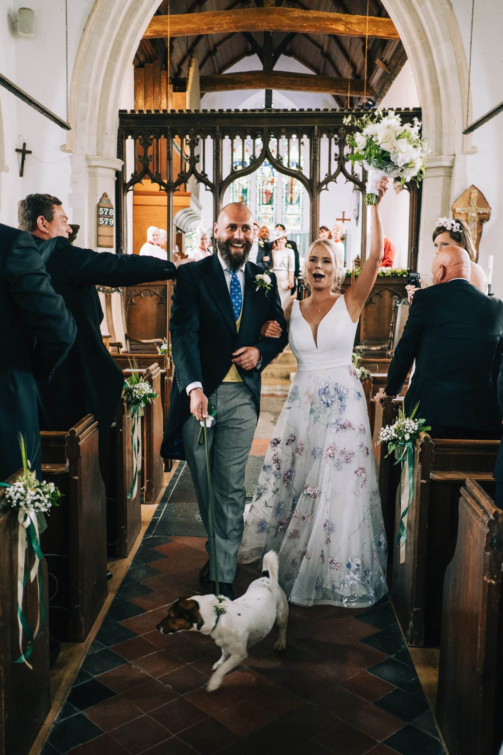 Bride and groom exit the church with their dog