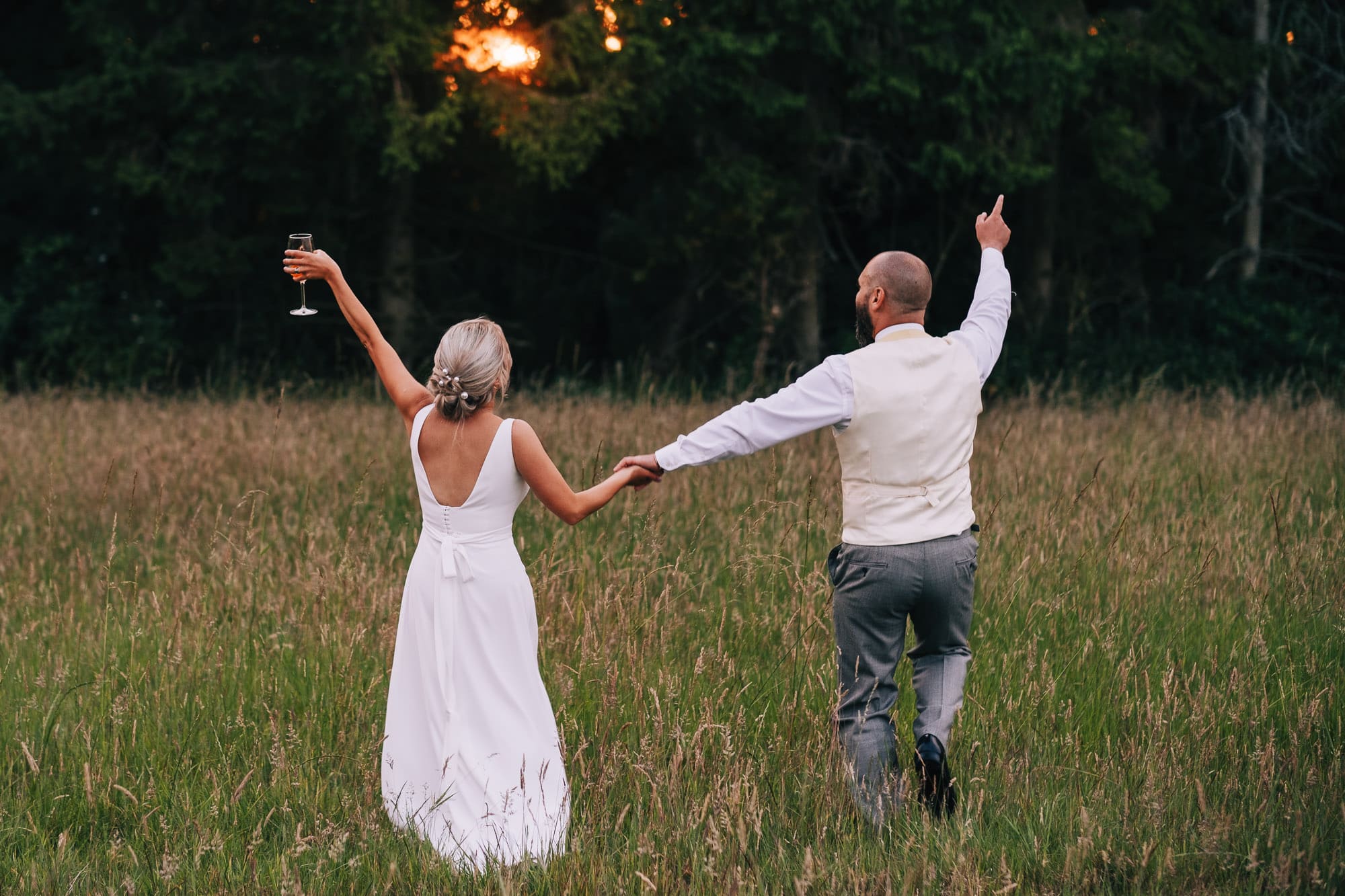 Bride and groom walking in fields
