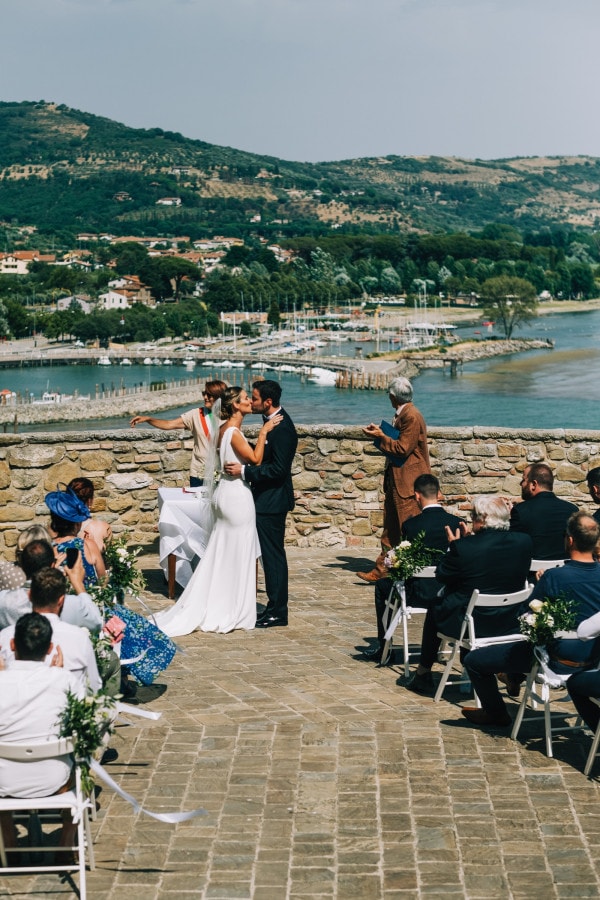 Bride and groom kiss at the top of La Rocca di Passignano sul Trasimeno