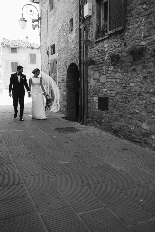 Bride and groom walking through the Tuscan streets of Passignano