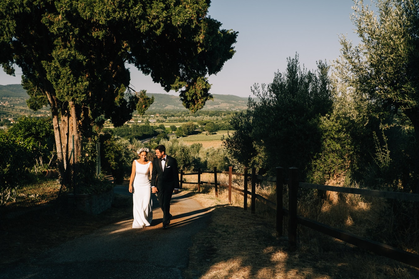 Bride and groom walking in the Tuscan sunlight