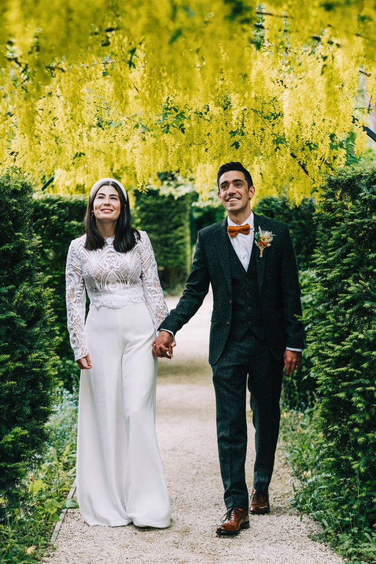 Bride and groom walking through Bridge End Gardens