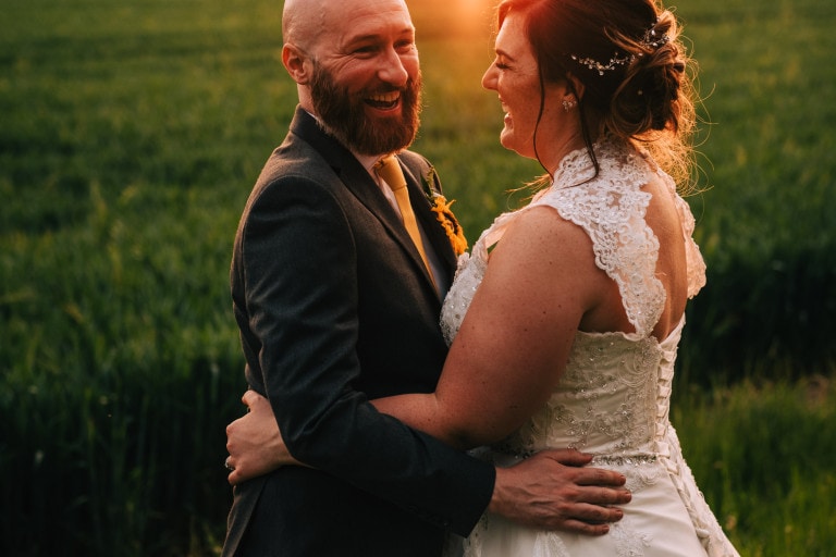 Bride and groom laughing at sunset