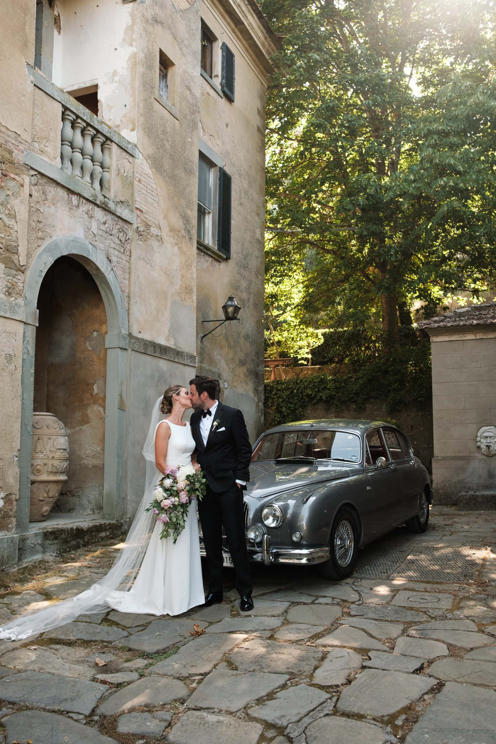Bride and groom kissing in front of La Dogana wedding venue