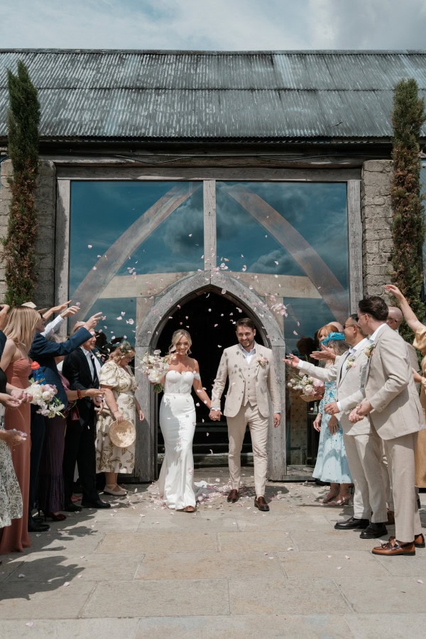 Bride and groom exiting Cripps Barn in the Cotswolds