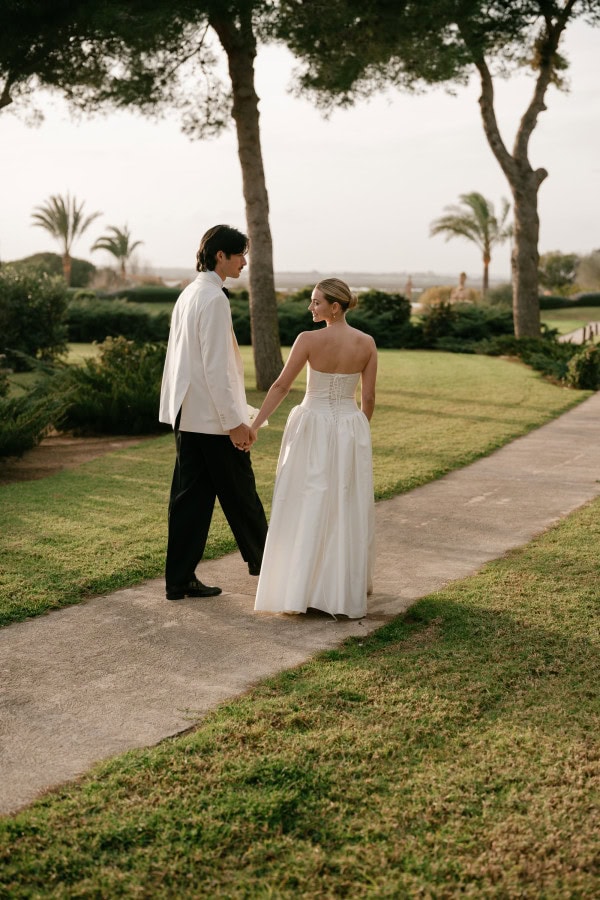 Bride looking over her shoulder walking in the gardens at Fontsanta Hotel