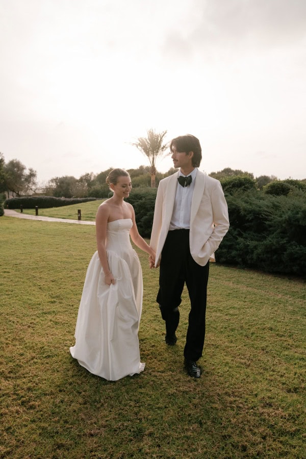 Bride and groom standing with the sun setting in the background