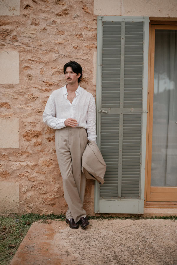 Groom leaning against the terracotta wall at Fontsanta Hotel