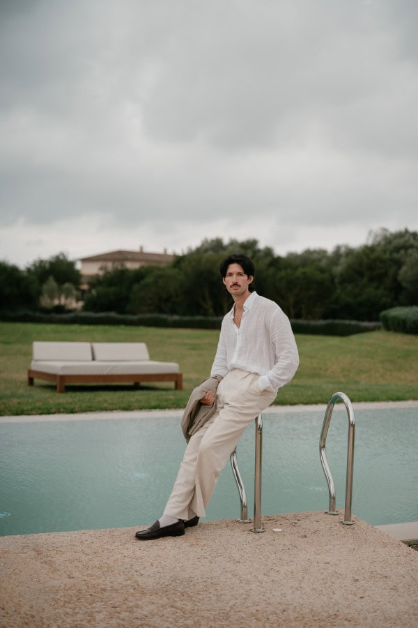 Groom leaning on the pool steps at Fontsanta Hotel