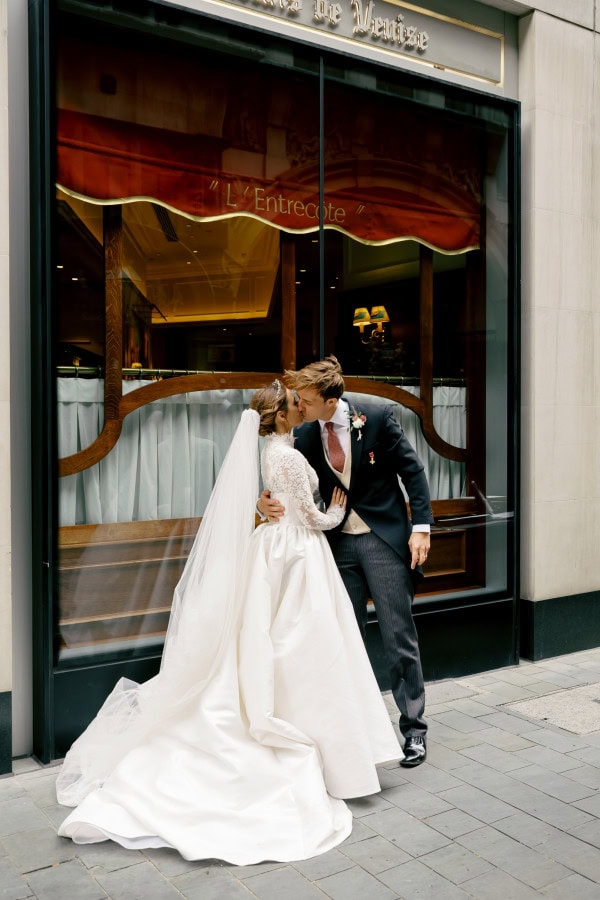 Bride and groom kissing outside Draper's Hall in London