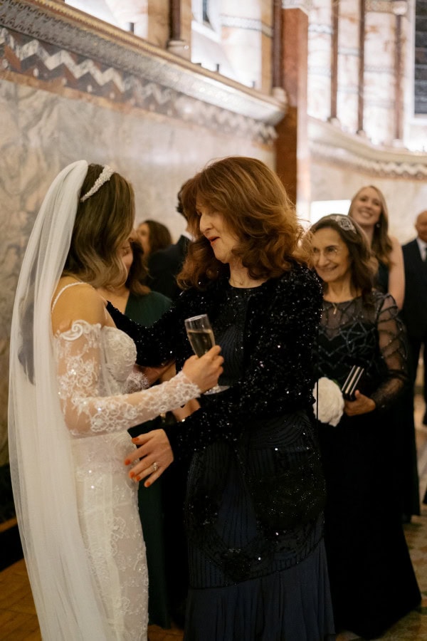 Bride and wedding guest embracing