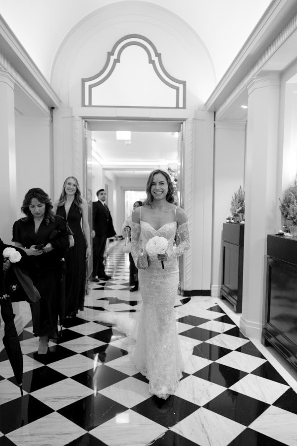 Bride smiling walking through Claridge's in London