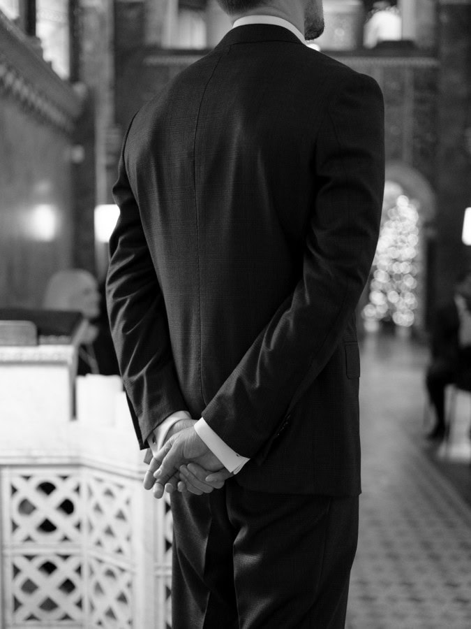 Groom with hands behind his back waiting for the entrance of the bride